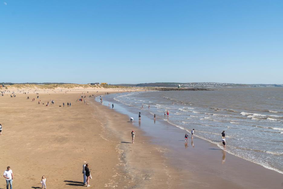 Families enjoying a sunny day at Sandy Bay Beach Porthcawl, Wales, UK.