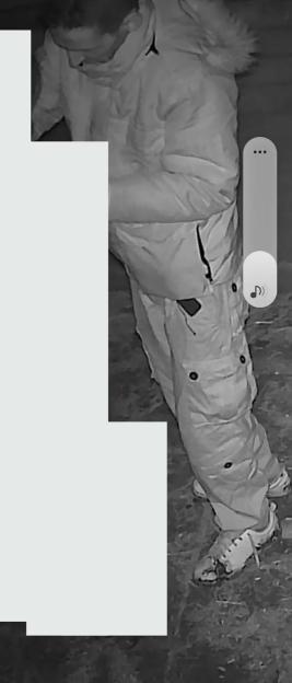 CCTV image of a man in a light-colored puffer jacket and cargo pants.