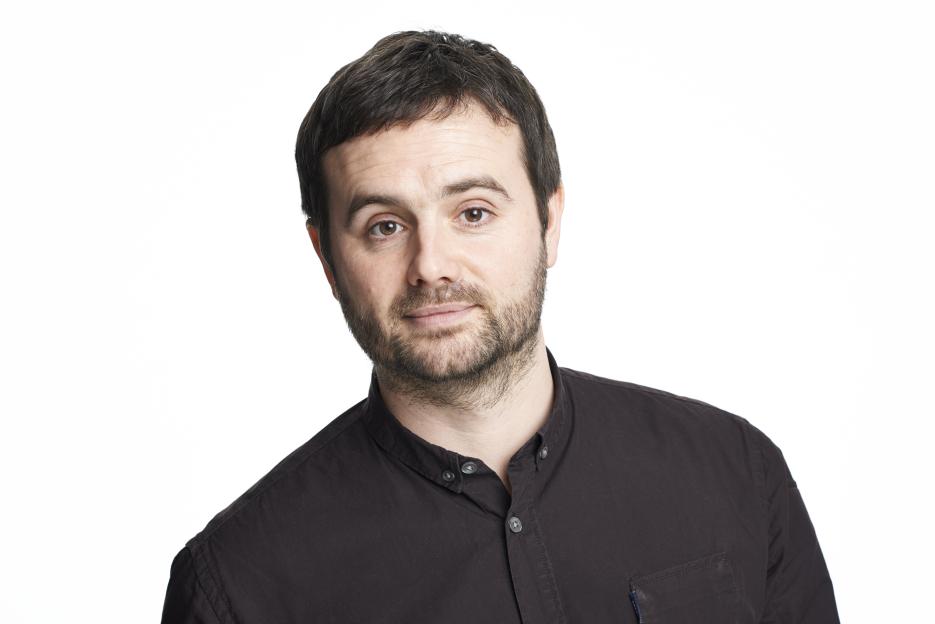 Colin Robertson, a journalist for The Sun, wearing a dark button-up shirt and a slight beard.