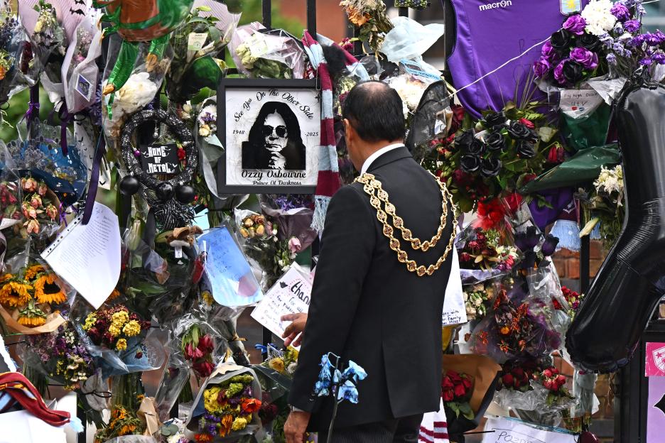 Lord Mayor of Birmingham, Councillor Zafar Iqbal, views floral tributes for Ozzy Osbourne, including a picture of Osbourne and a "Home of Metal" sign.