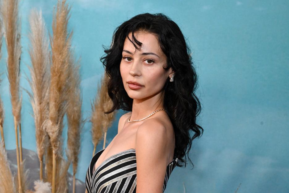 Alexa Demie wearing a strapless striped top and diamond necklace.