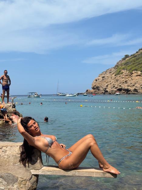 Matilda Draper in a silver bikini basking in the sun in Ibiza.