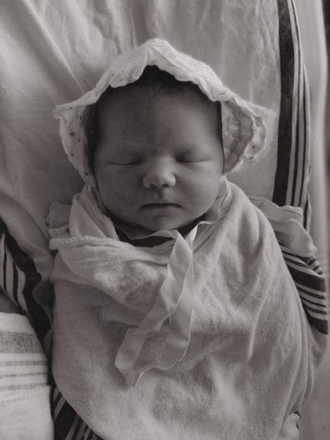 Demi Harman's baby sleeping in a bonnet and swaddle.