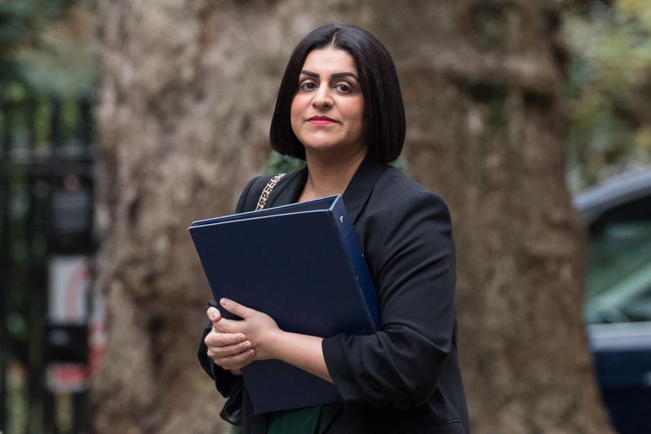 Shabana Mahmood in a black blazer holding a dark blue binder.
