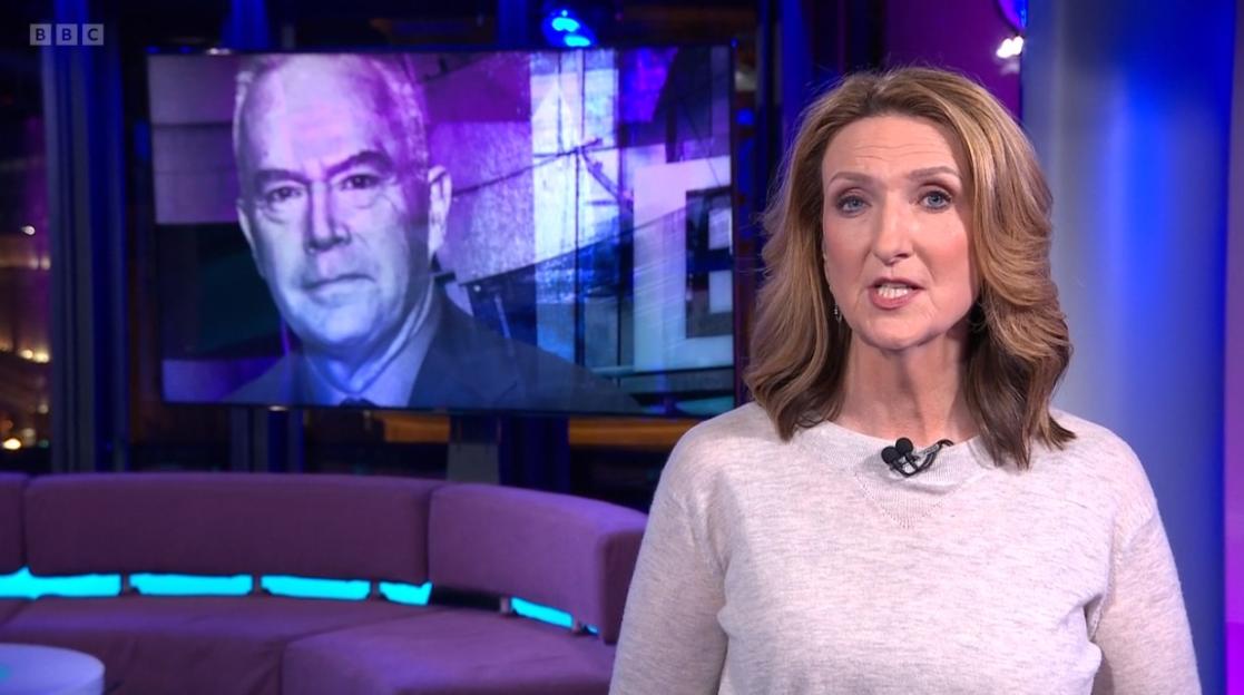 Victoria Derbyshire presenting Newsnight with Huw Edwards on a screen behind her.