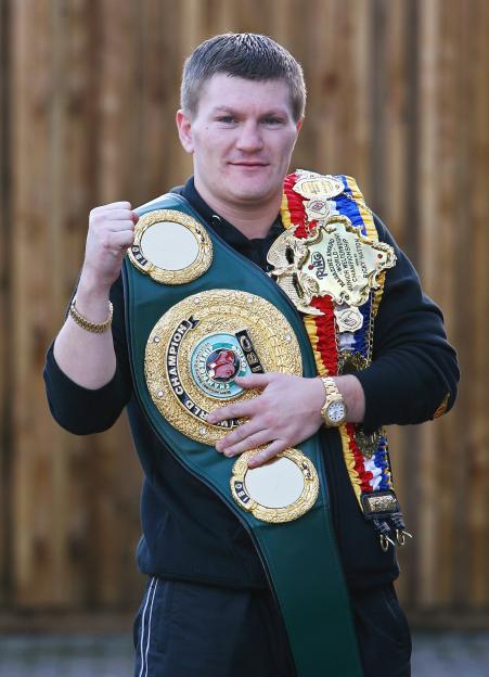 Ricky Hatton holding his boxing championship belts.