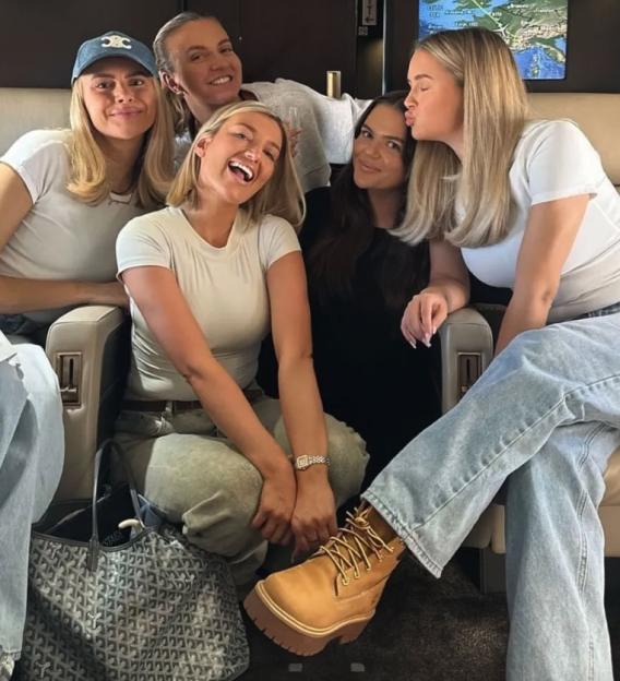 Molly, Perrie Sian, Zoe, and Tayla-Blue sitting in a plane cabin.