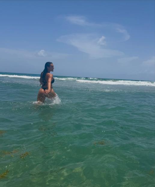 Georgina Rodriguez in a black bikini wading in the ocean.