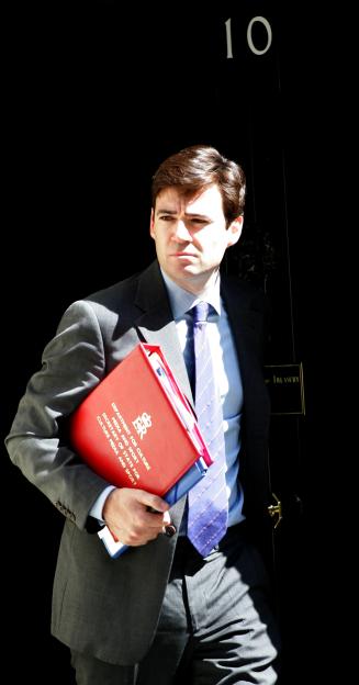 Minister Andy Burnham in Downing Street holding a red folder.