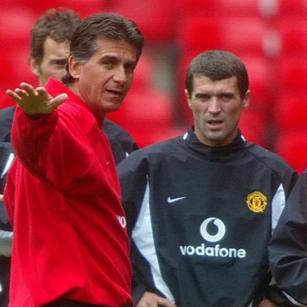Manchester United players Ryan Giggs, David Beckham, and Roy Keane with a coach during training.