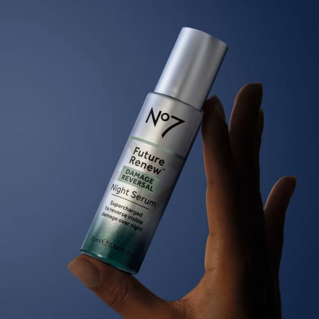 A hand holding a bottle of No7 Future Renew Night Serum.