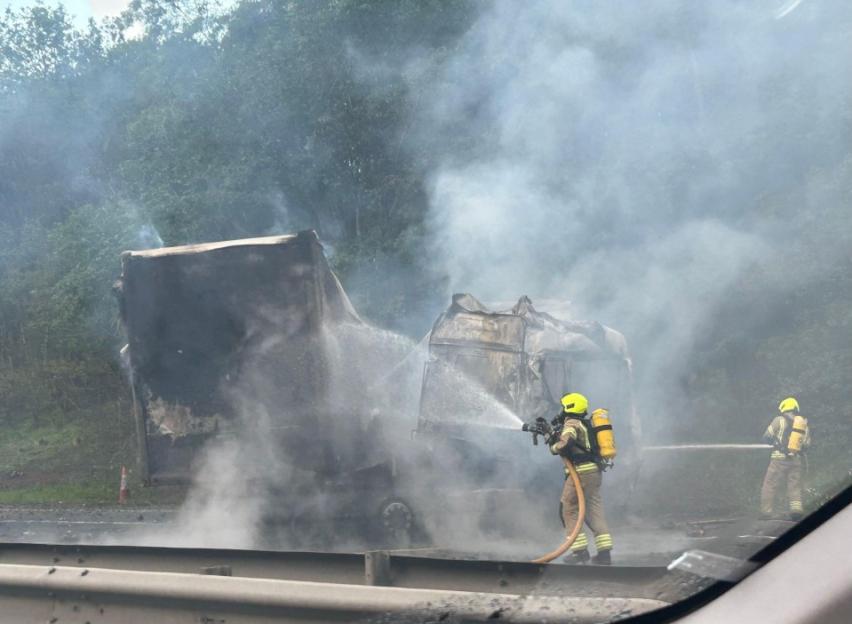 Firefighters extinguishing a serious multi-vehicle crash on the M1 in Leicestershire, UK.