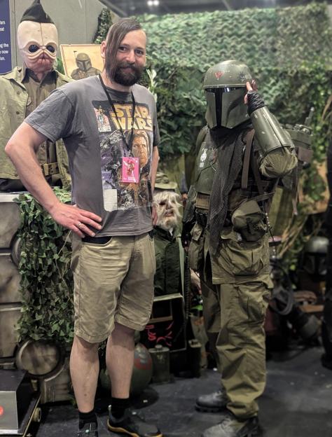Damian Lazewski, in a Star Wars t-shirt, stands next to a person in a Mandalorian costume.
