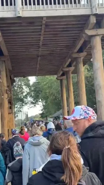 A large crowd of people evacuating under a wooden structure at Yorkshire Wildlife Park.
