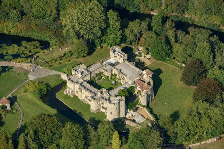 Aerial view of Allington Castle surrounded by a moat and lush greenery.