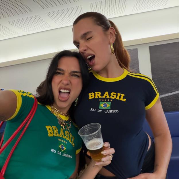 Dua Lipa and a friend making funny faces while wearing Brazil-themed shirts.