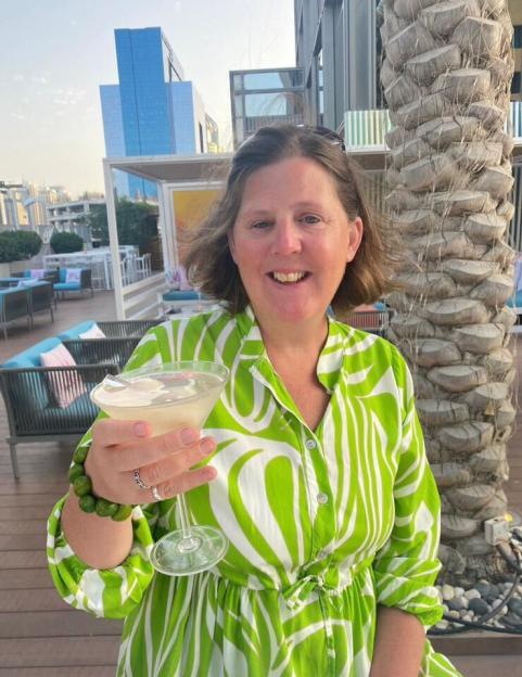Shona Sibary, 55, smiling and holding a cocktail.