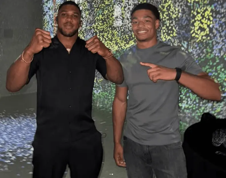 Anthony Joshua poses with a younger man.