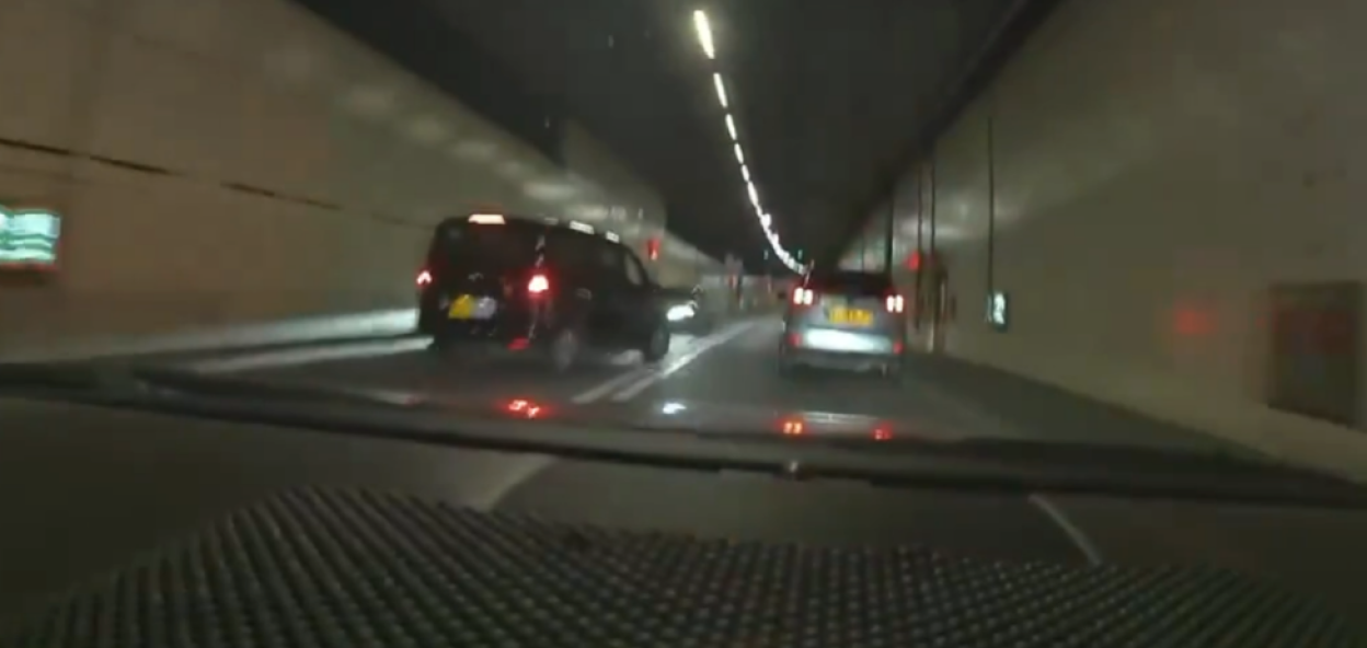 Driver's-eye view of cars in a tunnel.