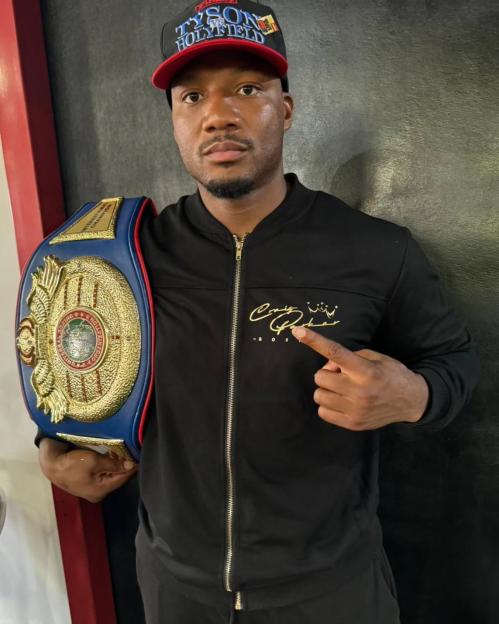 Craig Parker holding a boxing championship belt.