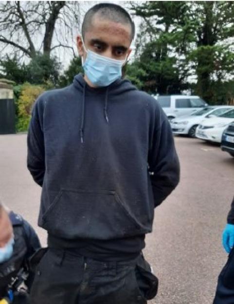 Jaswant Singh Chail in a black hoodie and blue surgical mask with his hands behind his back.