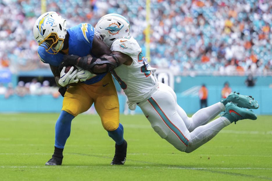 Miami Dolphins linebacker Jordyn Brooks (20) tackles Los Angeles Chargers running back Kimani Vidal (30).
