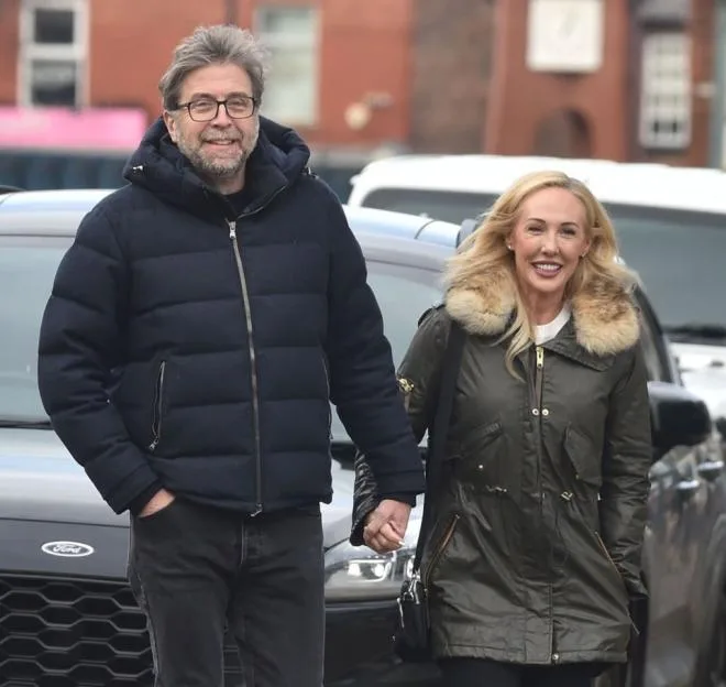 Mark Chapman and his girlfriend Clere Collier holding hands while walking in Manchester.