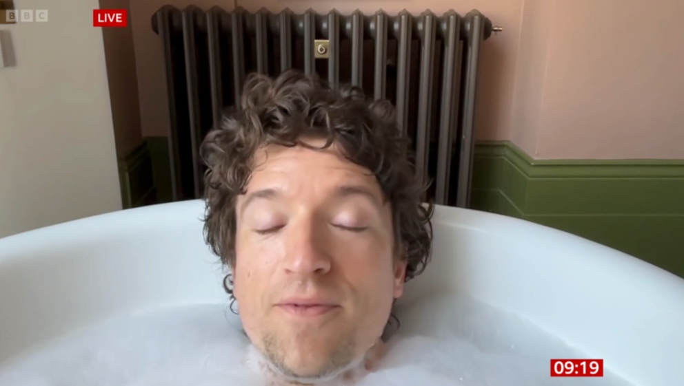 Greg James in a bathtub full of bubbles.