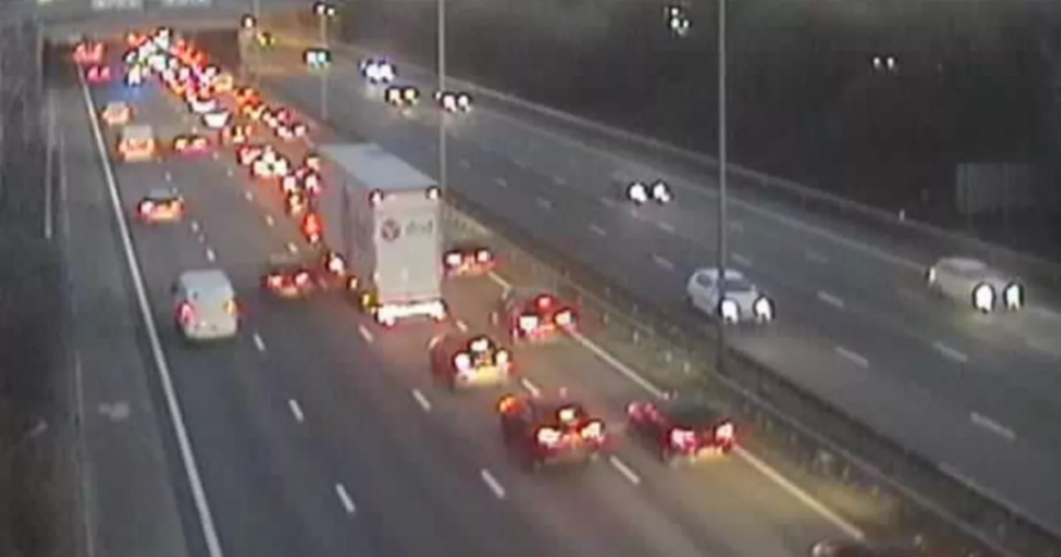 Traffic moving on a multi-lane highway at night, with one side experiencing heavier congestion.