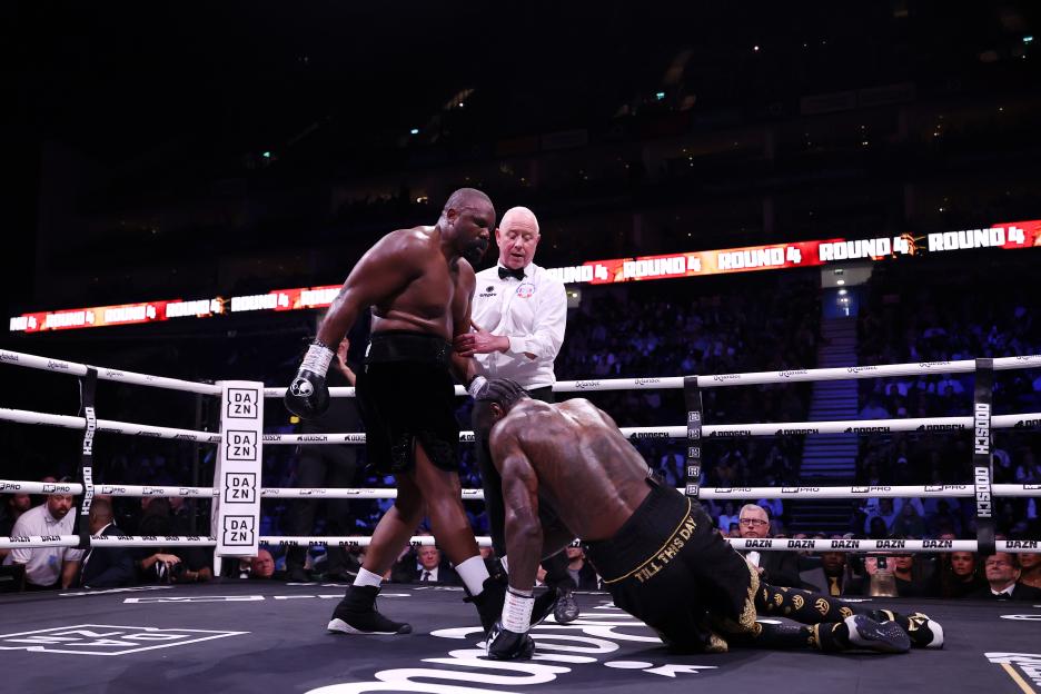 Deontay Wilder falls to the ground after a clinch with Derek Chisora during a heavyweight boxing match.