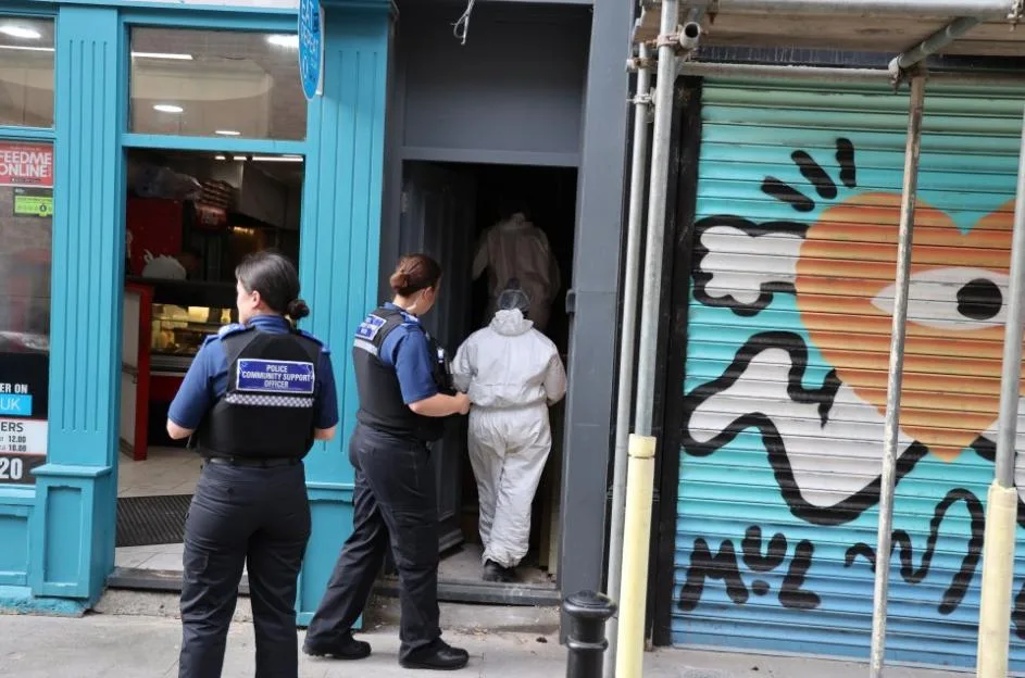 Police officers and forensic investigators at a crime scene.
