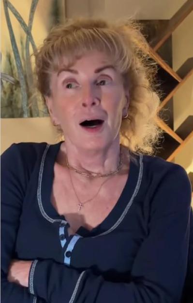 Bev Callard talking to someone off-camera, with her arms crossed.