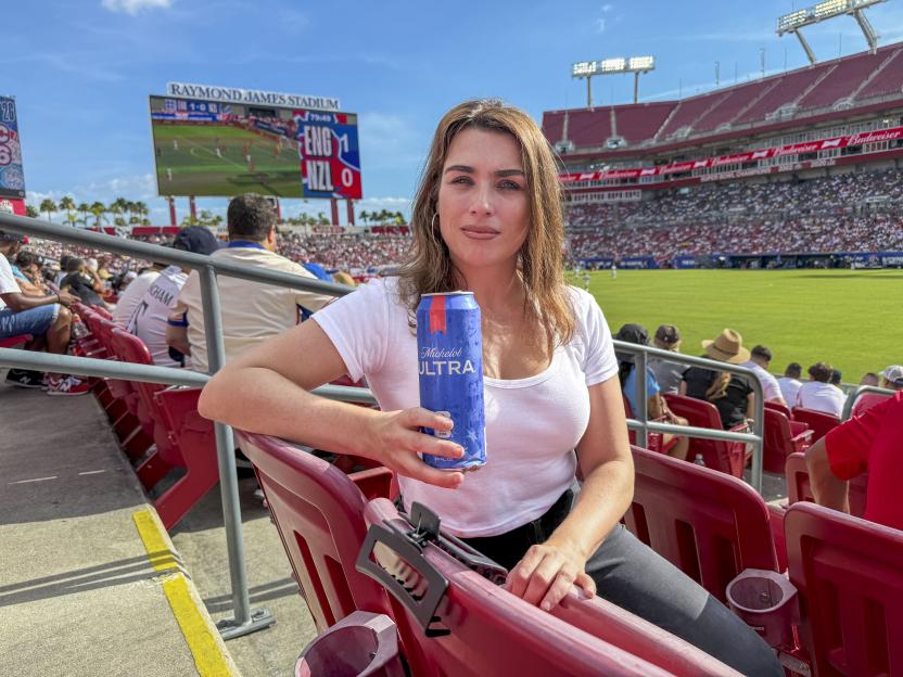 Scarlet Howes, The Sun's US Editor, holding a Michelob Ultra beer can in a stadium.