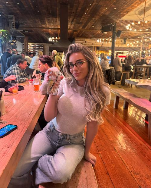 Lana from Love Island at a restaurant, holding a drink.