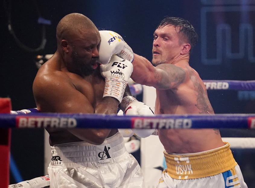 Derek Chisora lands a punch to Oleksandr Usyk's face during their heavyweight contest.