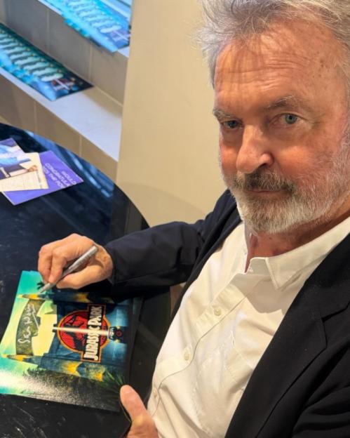 Actor Sam Neill signing a "Jurassic Park" item.