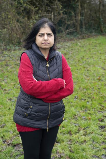 Susan Kohli, daughter of Bhim Kohli, stands in a grassy park.
