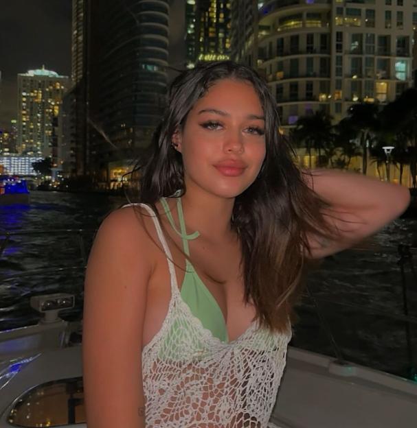 Deia Pizzey on a boat at night with a city skyline in the background.