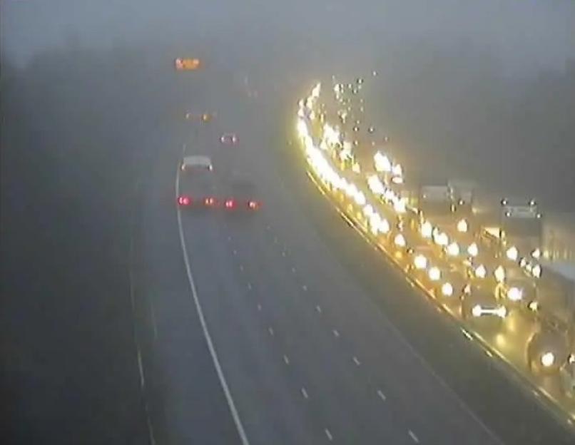 Foggy highway with heavy traffic congestion.