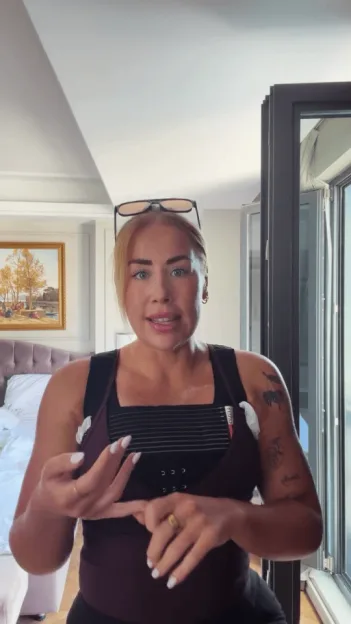 Polly Sellman talking about her breast implants while wearing a post-surgery compression bra.