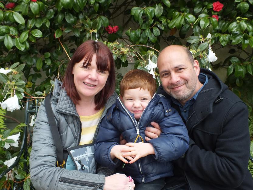 Family portrait in front of flowering plants.