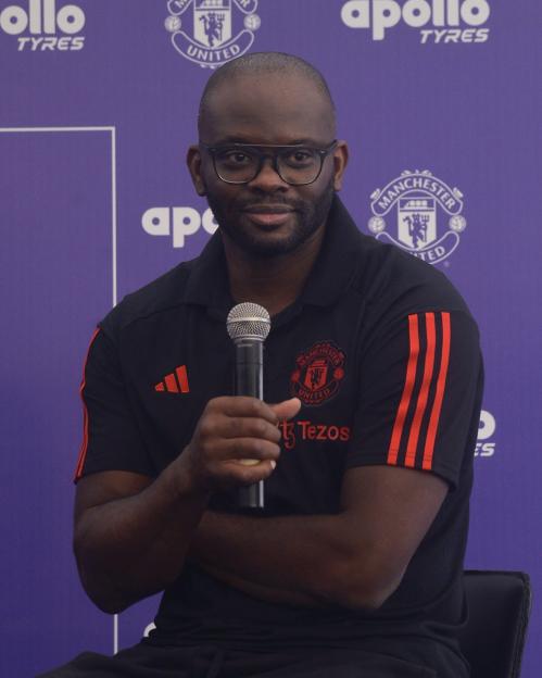 Former French soccer player Louis Laurent Saha speaking into a microphone.