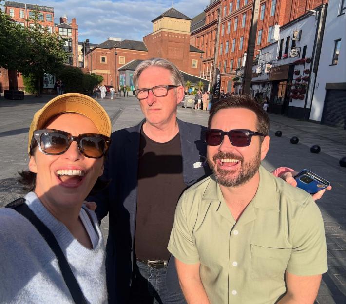 Line of Duty actors Vicky McClure, Adrian Dunbar, and Martin Compston posing together outside.