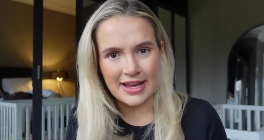 Molly-Mae Hague smiling with a crib in the background, likely discussing her baby's gender and name.