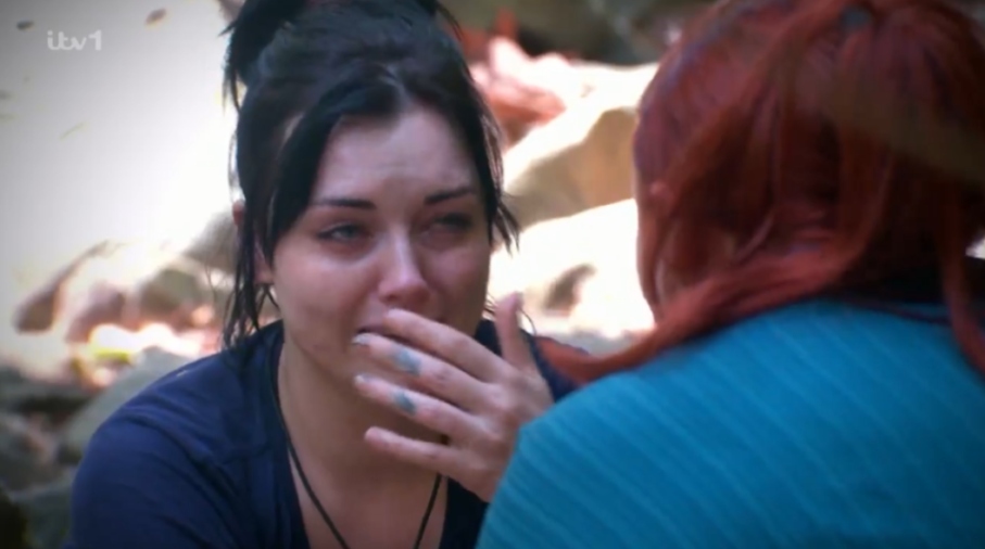 Woman crying while speaking to another person.