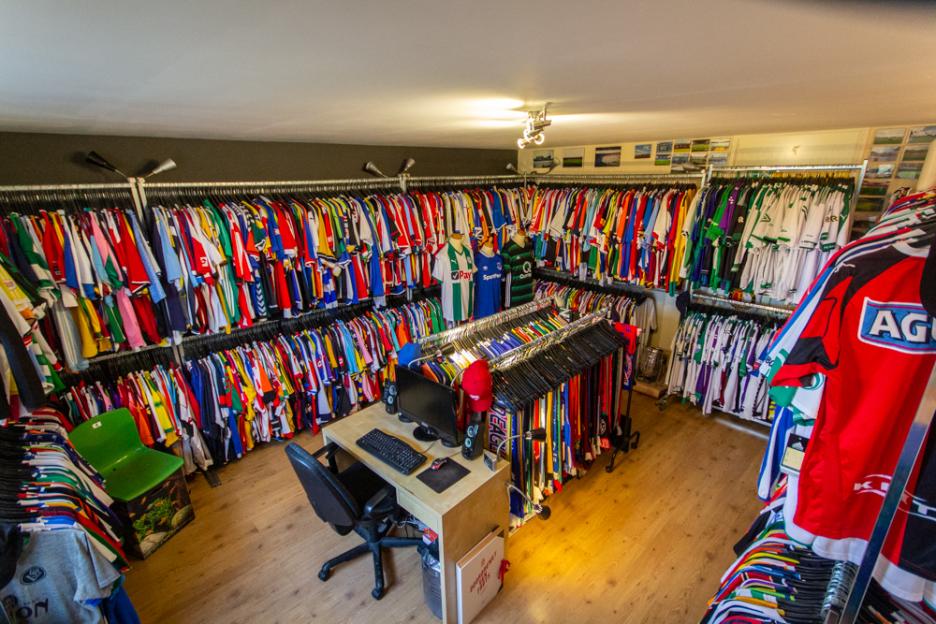 Room filled with racks of colorful sports jerseys.