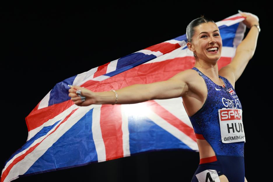 Amy Hunt celebrates with a British flag after winning the women's 100 meters final.