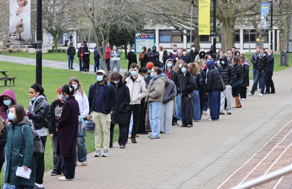 Students queue for antibiotics outside a building of the University of Kent in Canterbury.