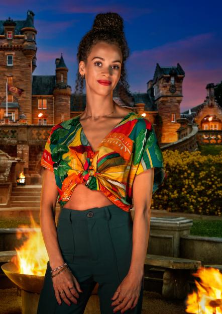Roxy, 32, a recruiter from Amsterdam, poses in front of a castle and a fire pit.