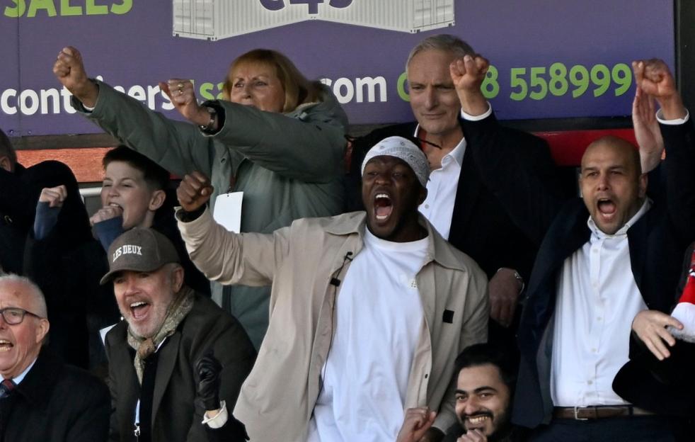 Fans cheering at Dagenham and Redbridge v Torquay United football match.